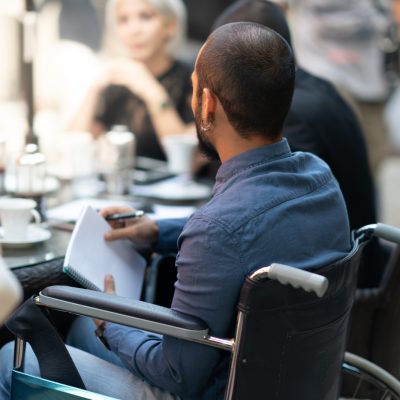 young disable businessman is at meeting sitting on his wheelchair.